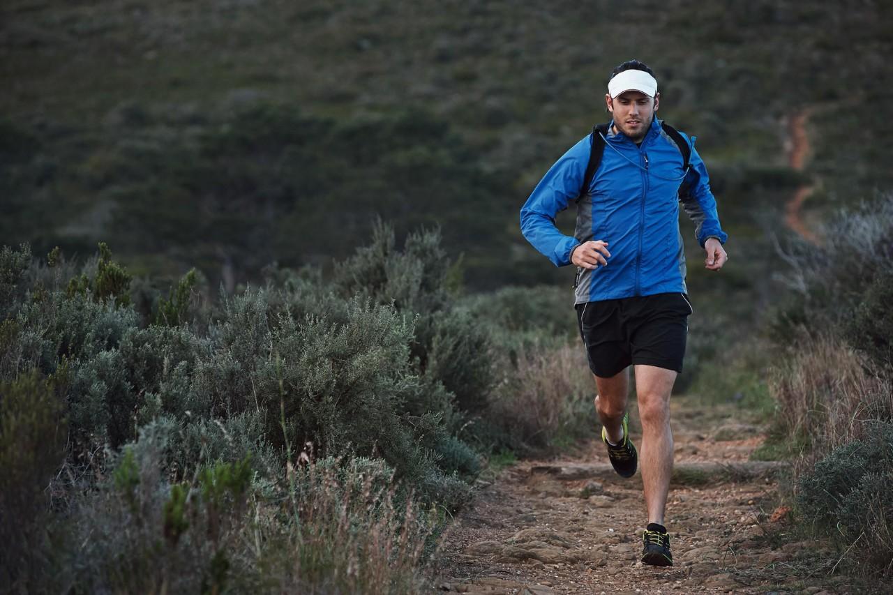 Trail running man exercising outdoors for fitness